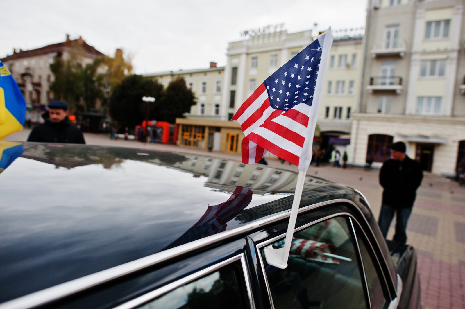 Luxury transportation for corporate roadshows featuring a line of black cars with American flags.
